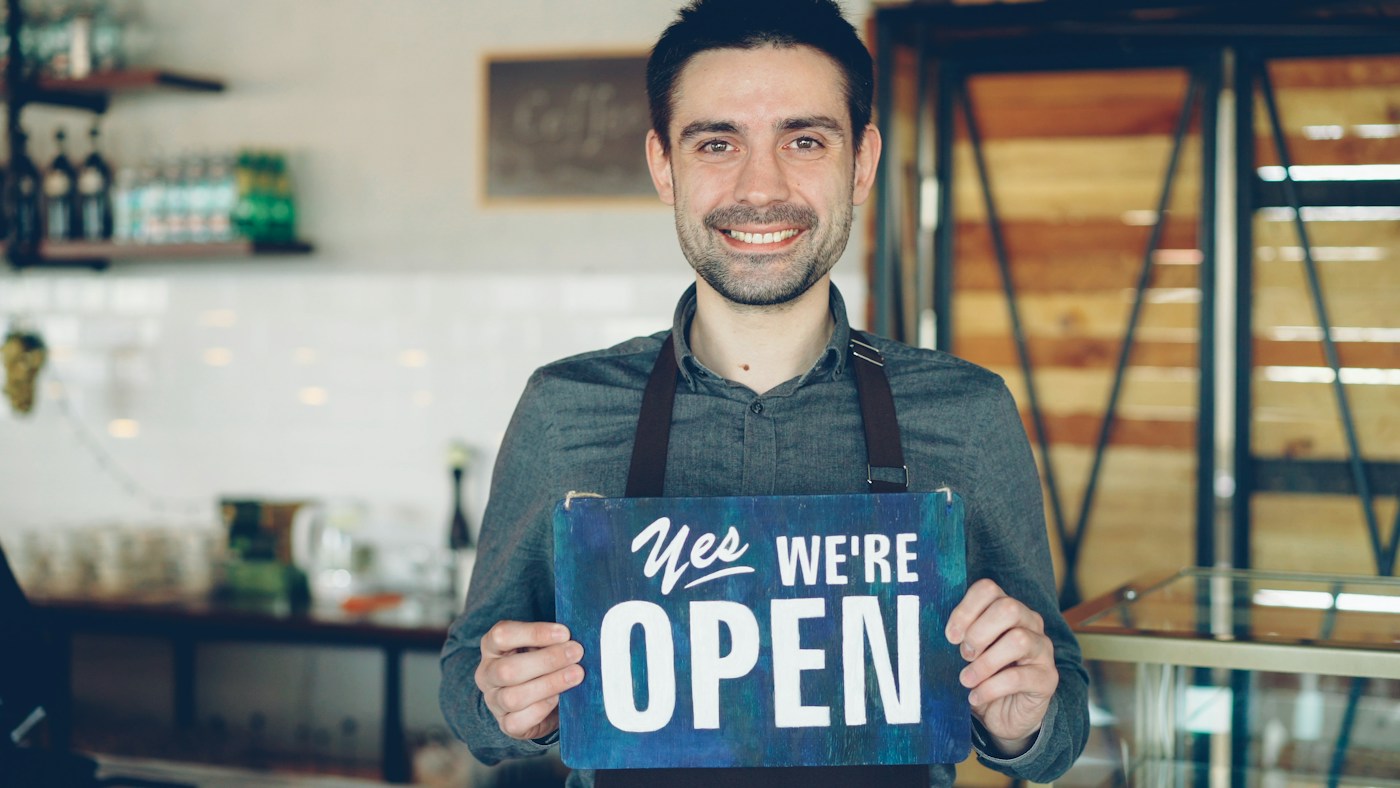 An independent café operator welcoming customers