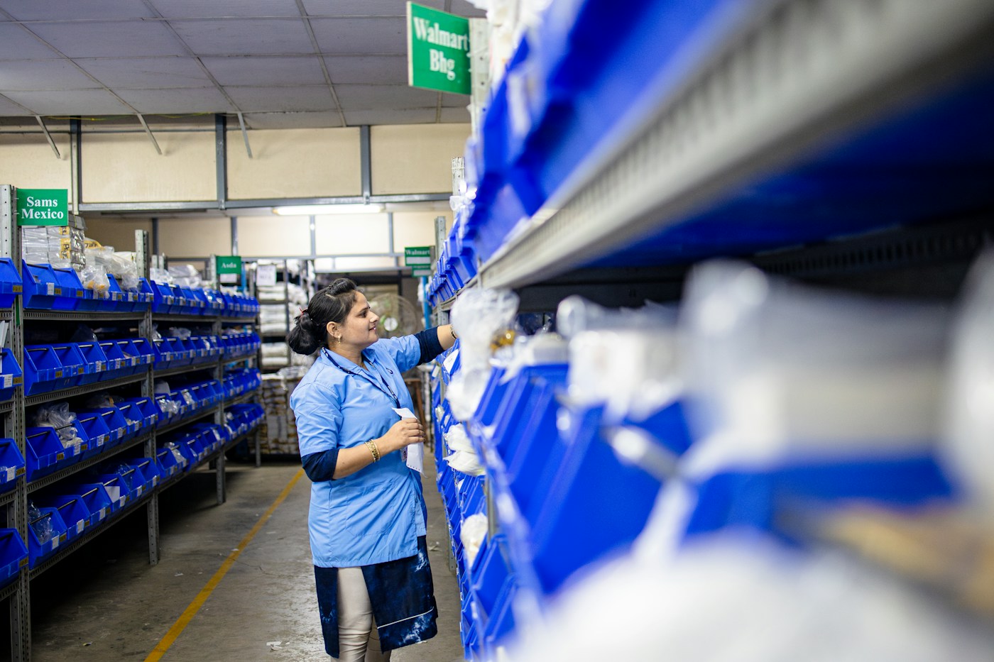 A warehouse worker selecting parts from storage bins